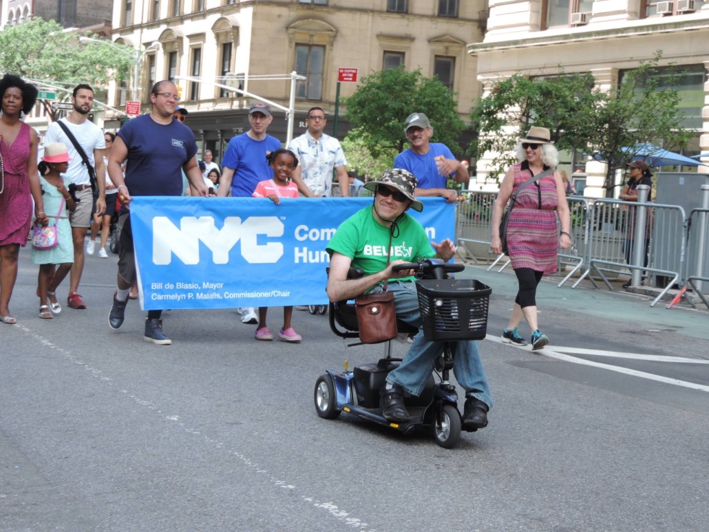 A group of marchers carry a blue sign at Disability Pride NYC.